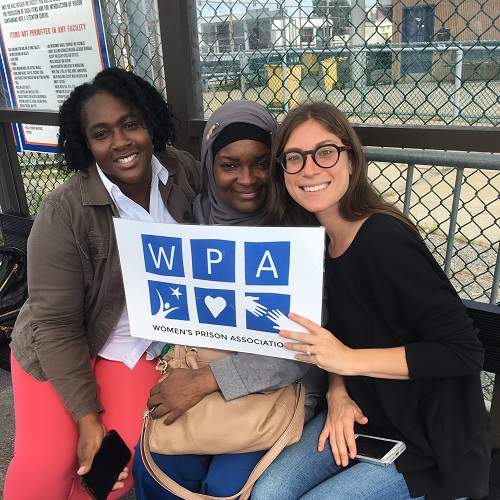 Three women holding the WPA logo